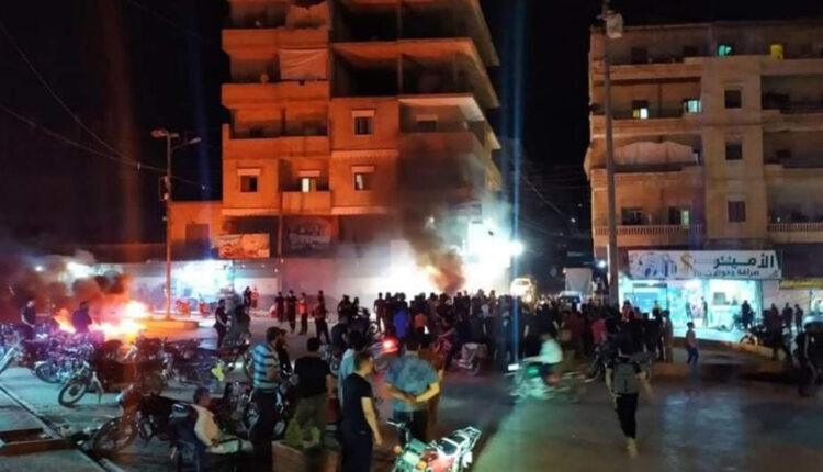 People protesting in front of power company building in the city of Afrin