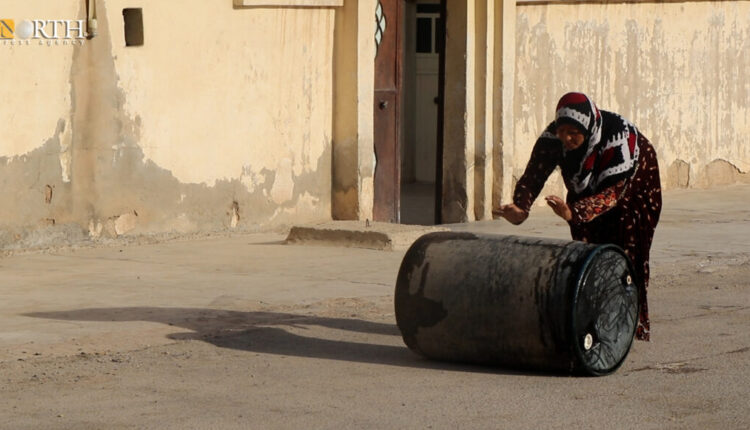 A woman rolls a water barrel to her house after being filled from tanks in Hasakah – North Press