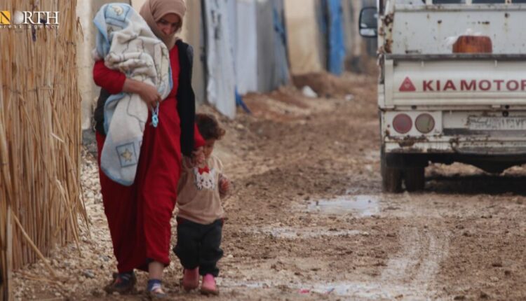 A displaced woman in Washokani camp in the north of Hasakah, northeast Syria, hardly walks with her daughter because of mud – North Press