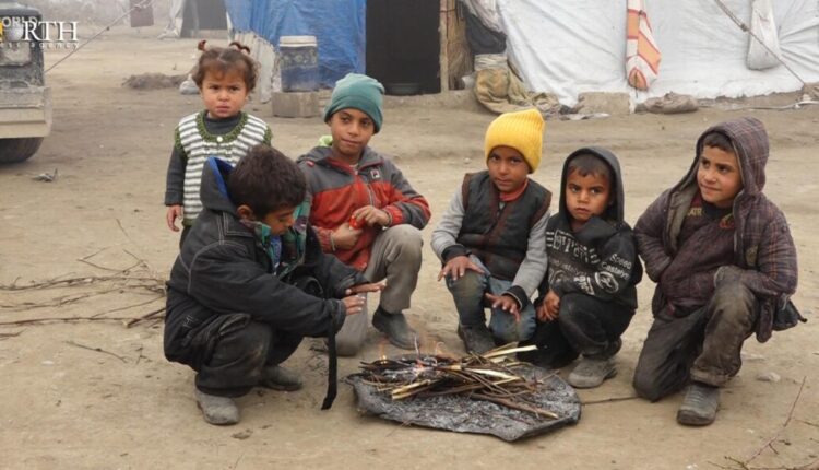 Children sitting around a fire trying to get some warmth in al-Younani makeshift camp, south of Raqqa in northern Syria – North Press