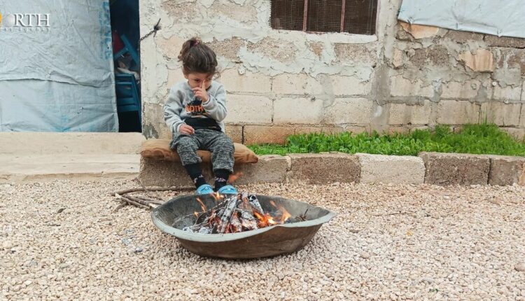 A displaced little girl from Afrin in Barkhodan camp in the northern countryside of Aleppo, north Syria, sits by the fire to get some warmth – North Press