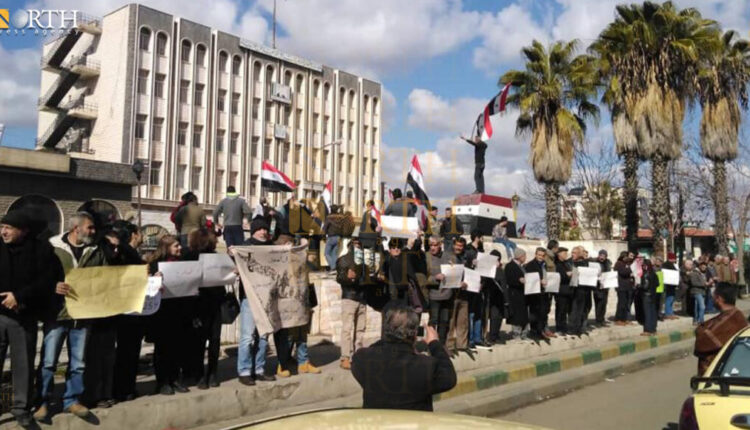 Protesters in Karama Square in the city of Suwayda, south Syria. Government supporters standing behind and rising Syrian flags - North Press