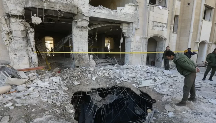 A member of the Syrian security forces checks a crater caused by a reported Israeli missile strike in Damascus, Syria, on March 31, 2023 – AFP