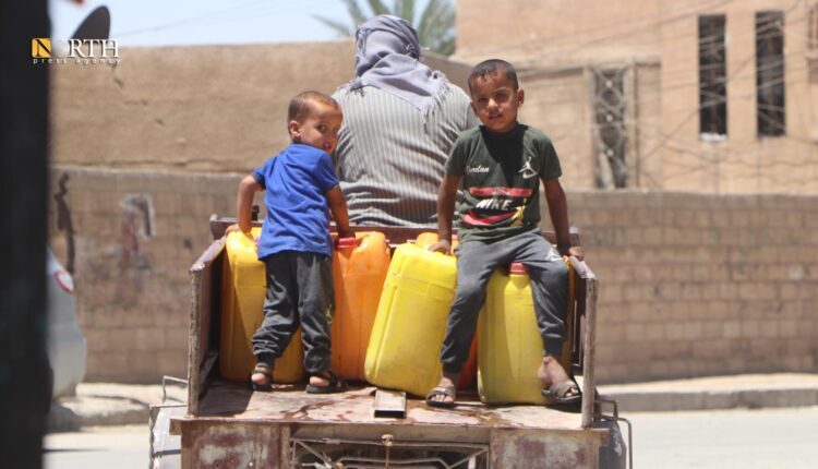 Two children with their father on a three wheeler motorcycle looking for water in the city of Hasakah in northeast Syria – North Press
