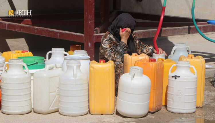 A woman surrounded by a number of empty gallons is waiting to fill them with water as the NE Syria's city of Hasakah has gone through an acute water shortage – North Press