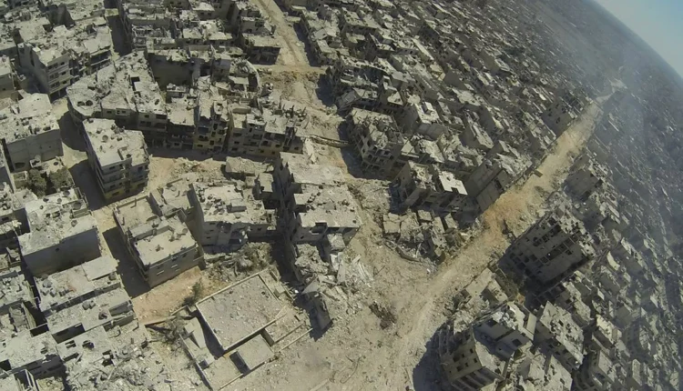 Rubble and smoke after Syrian government forces retook al-Khaldiyah neighborhood in Homs, central Syria, in 2013 – The Mirror