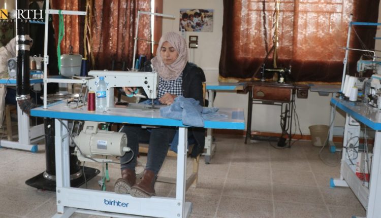 A woman operating a sewing machine in one of the sewing workshops run by the Foundation of Free Women in Syria. – North Press