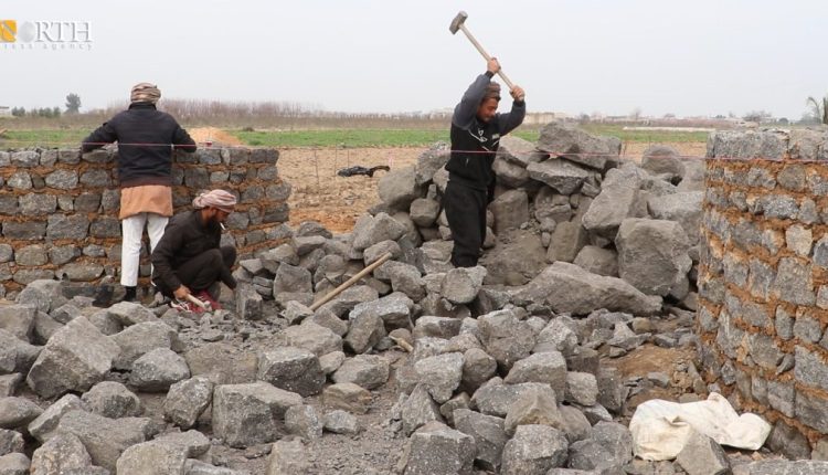 Workers breaking basalt rocks and using them in construction in Raqqa countryside, north Syria - North Press