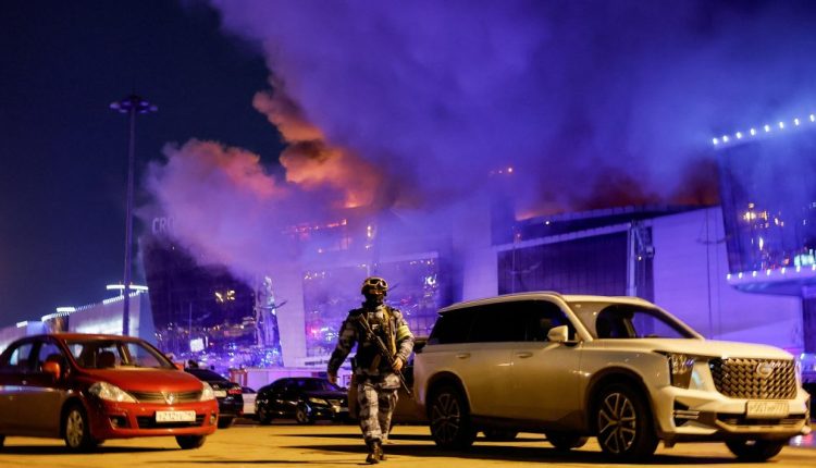A security guard stands against the fired building in Moscow on March 22, 2024.