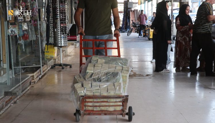 A store owner carries bags of Syrian money in markets of Qamishli city in northeastern Syria – North Press