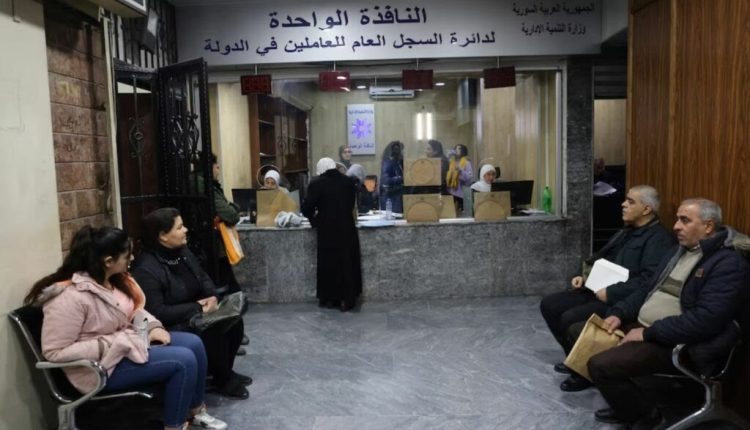 People waiting inside a government building in a Damascus suburb – January 8, 2025 (Reuters).