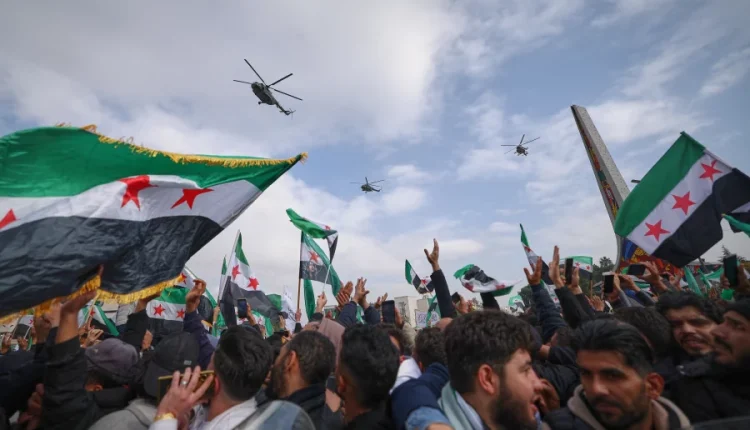 Army helicopters fly overhead during a parade by the new Syrian army marking the first anniversary of the ousting of the Bashar Assad regime in Damascus, Syria, Dec. 8, 2025. – AP
