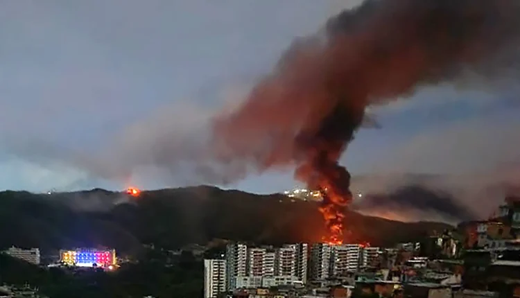 Fire at Fuerte Tiuna, Venezuela's largest military complex, is seen from a distance after a series of explosions in Caracas on Jan. 3, 2026. – STR, AFP via Getty Images