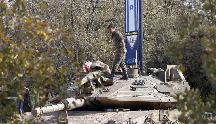 An Israeli soldier arranges gear atop an army tank deployed in the Golan Heights around the buffer zone in southwest Syria on Dec. 8, 2024. - AFP