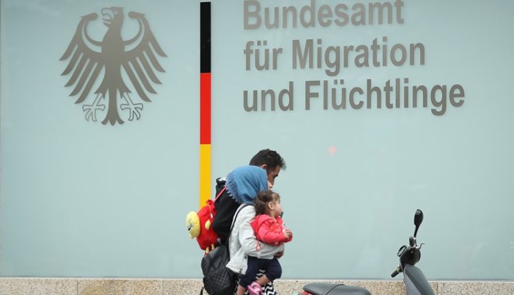 A family walks past the Federal Office for Migration and Refugees (BAMF) in Berlin on May 18, 2018. - Getty Images
