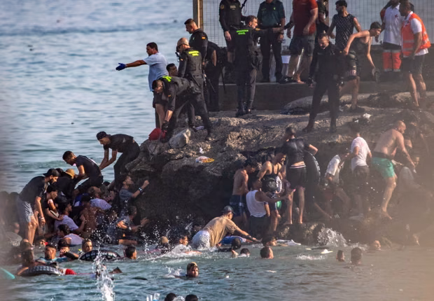 People try to cross from Morocco into the Spanish enclave of Ceuta on July 30, 2026. – AP