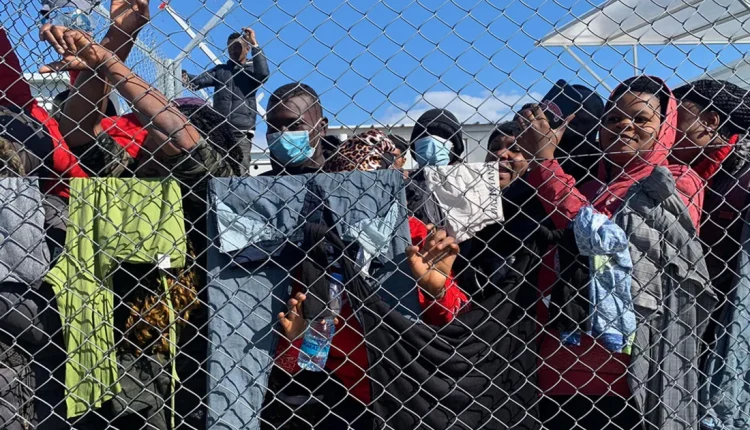 Migrants gather behind a fence at the Pournara reception center in Cyprus, where more than 3,000 people were housed at the facility’s peak in 2022. – Cyprus Mail