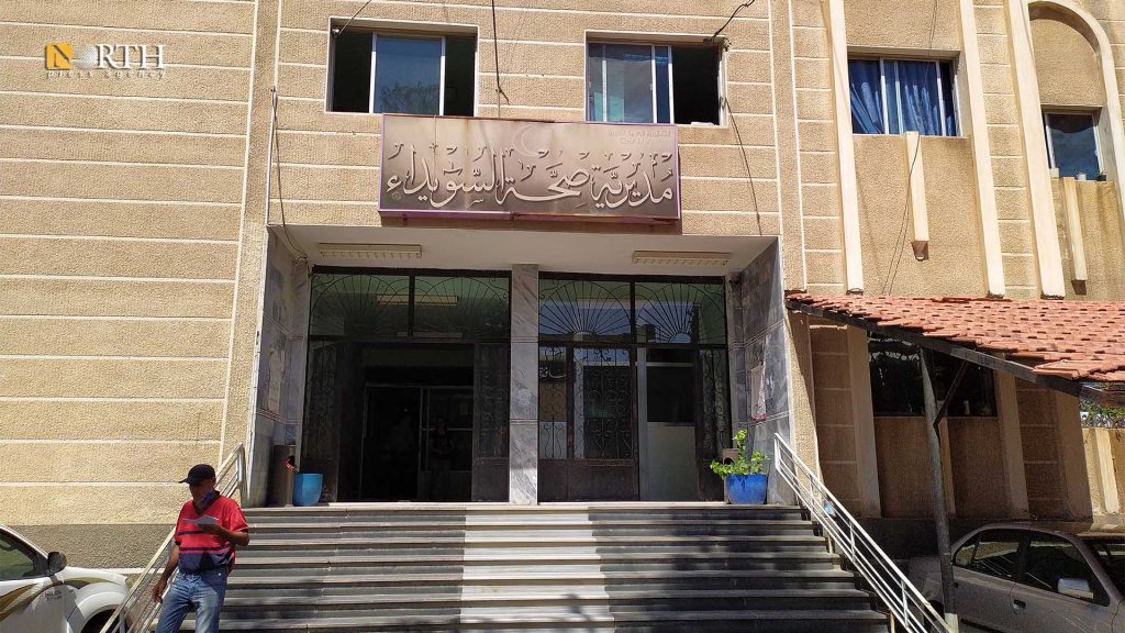 السويداء - موظف يحمل أوراقاً وهو يخرج من مديرية الصحة في المدينة- نورث برس