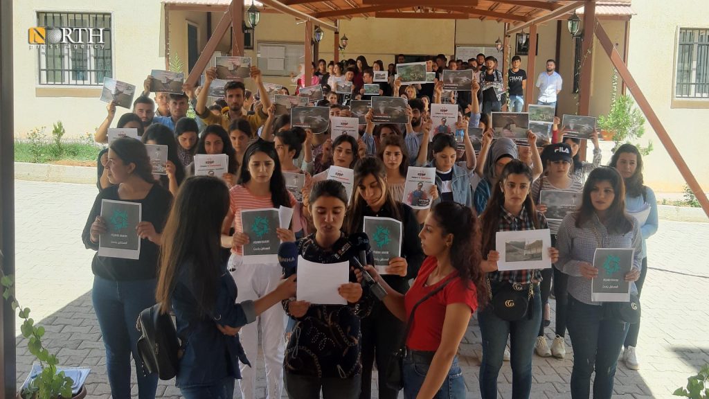 طلاب جامعة كوباني يرفعون لافتات اثناء إلقاء بيان في مبنى الجامعة