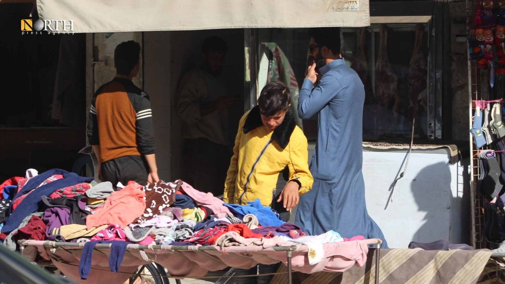طفل يعمل على بسطة في سوق شارع تل أبيض في الرقة ـ نورث برس