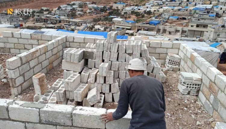 نازح يبني غرفة اسمنتية في مخيم بريف إدلب الشمالي- نورث برس/ أرشيفية