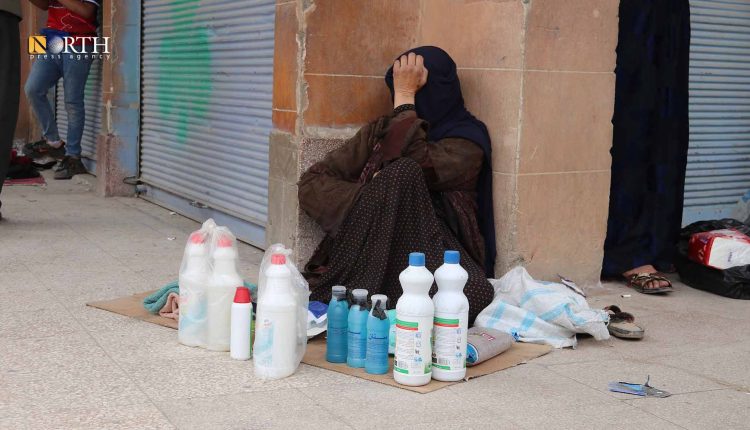 نازحة تبيع المعونات التي استلمتها من المنظمات على رصيف شارع بديرك- نورث برس