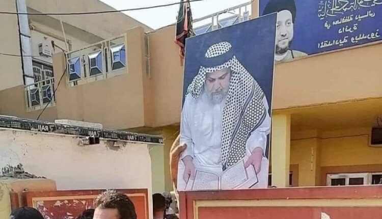 متظاهرون يرفعون صورة زعيم "التيار الصدري" في مقر لتيار "الحكمة" بالعاصمة بغداد
