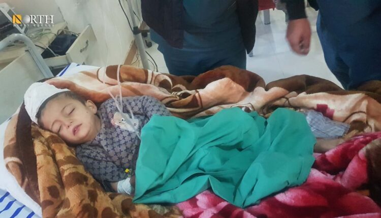 الطفل عبدو مصطفى حنيفي ملقي على سرير في مشفى كوباني بعد أن بُترت ساقه نتيجة القصف التركي على كوباني – نورث برس