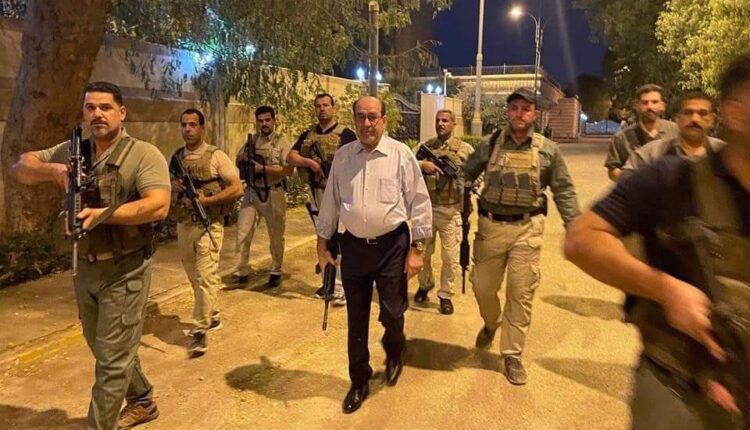 نوري المالكي مسلحاً يتوسط عدداً من المرافقين المسلحين في أحد شوارع بغداد