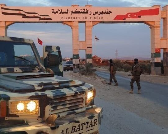 مسلحان أمام مدخل ناحية جنديرس غربي عفرين – انترنيت / تعبيرية