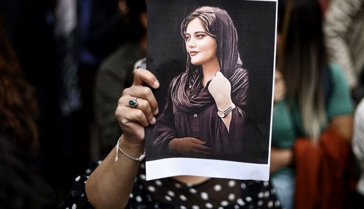 متظاهرة تحمل صورة مهسا أميني خلال مظاهرة أمام السفارة الإيرانية في بروكسيل (23 أيلول 2022 - أ ف ب).