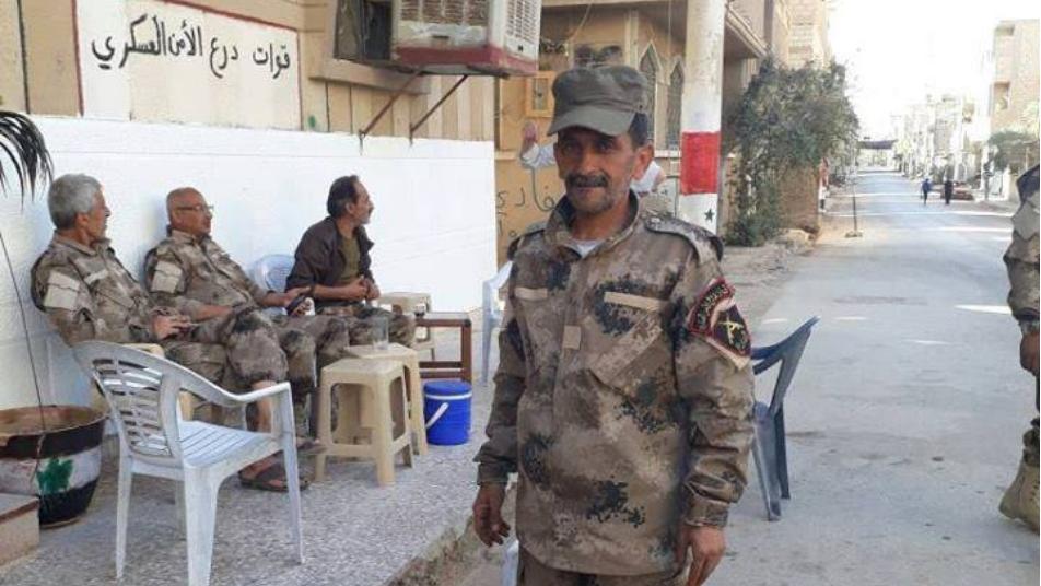 عناصر للأمن العسكري أمام مقر عملهم ببلدة البوكمال شرقي دير الزور - متداول