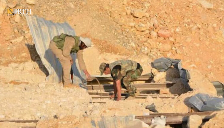 عناصر من لواء فاطميون يرفعون الأنقاض عن أحد المقرات بعد تعرضه لقصف إسرائيلي – أرشيفية/نورث برس