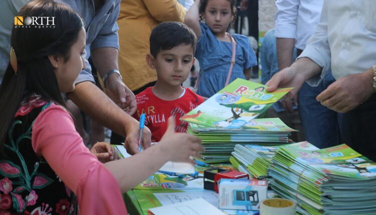 من مكان توزيع العدد الأول لمجلة رونا بحديقة القراءة في القامشلي – نورث برس