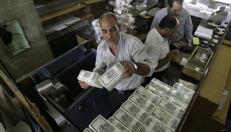 صرافون يحملون فئات نقدية من الليرة السورية – انترنيت