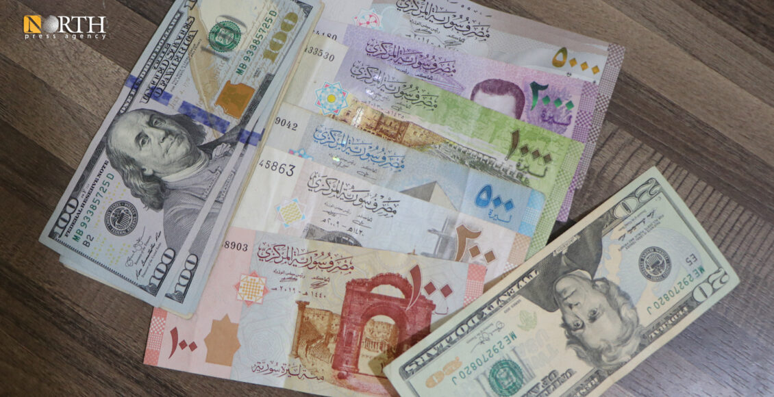 فئات نقدية للدولار الأميركي و الليرة السورية بأحد محال الصرافة بالحسكة - نورث برس