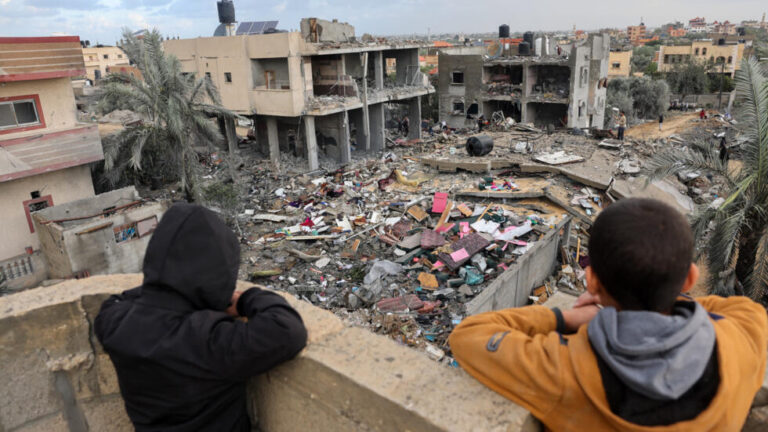 أطفال فلسطينيون في رفح جنوبي قطاع غزة أمامهم دمار ناجم عن القصف الإسرائيلي - أ ف ب