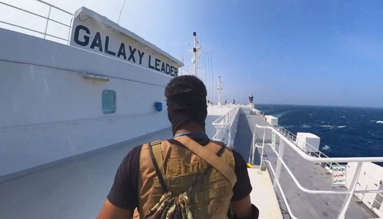 مقاتل حوثي يقف على سفينة الشحن جالاكسي ليدر في البحر الأحمر