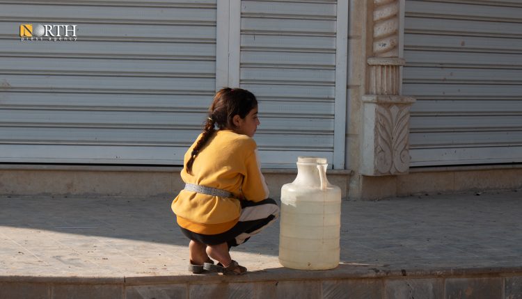 طفلة تنتظر دورها لتعبئة مياه الشرب في ظل أزمة تعيشها شمال شرقي سوريا - نورث برس