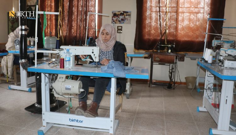 امرأة تعمل على آلة الخياطة في إحدى ورش الخياطة التابعة لمنظمة وقف المرأة - نورث برس 