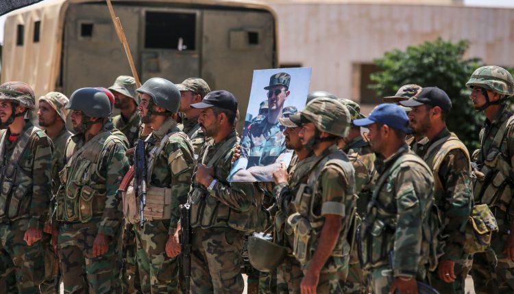 عناصر في الجيش السوري أحدهم يرفع صورة للرئيس بشار الأسد - انترنيت