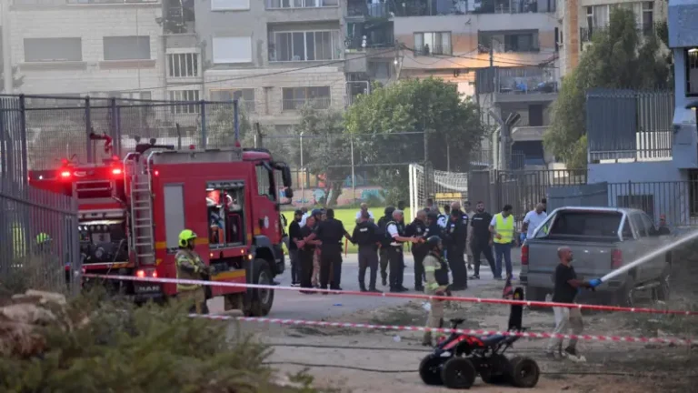 فرق إطفاء وقوات أمنية في محيط ملعب بلدة مجدل شمس في الجولان بعد الهجوم الصاروخي - رويترز