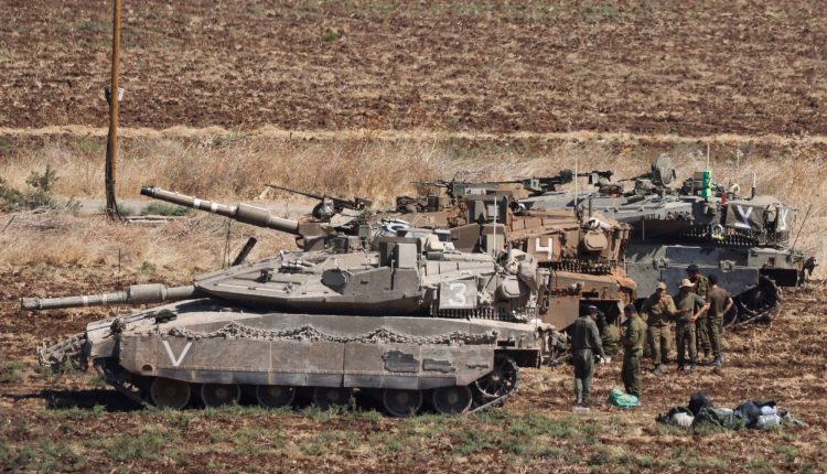 جنود يقفون بجوار دبابات الجيش الإسرائيلي - رويترز