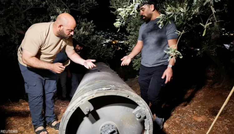 فلسطينيان يفحصان قذيفة أطلقتها إيران باتجاه إسرائيل - رويترز