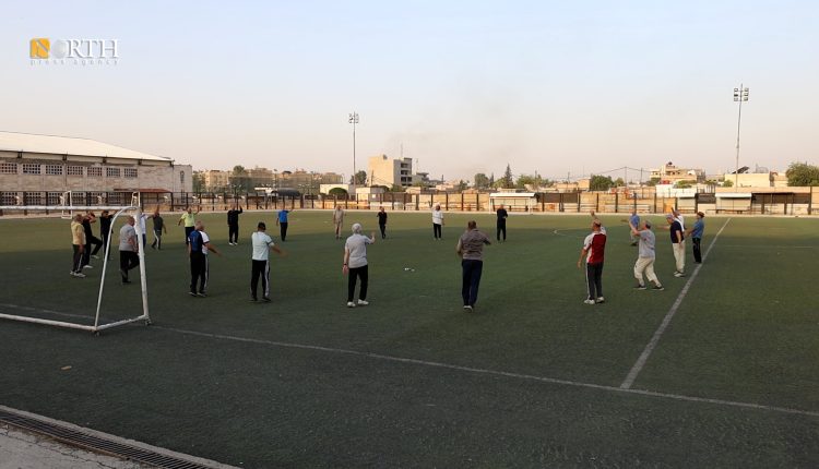 مجموعة أشخاص يمارسون الرياضة في ملعب هيثم كجو بمدينة القامشلي - نورث برس