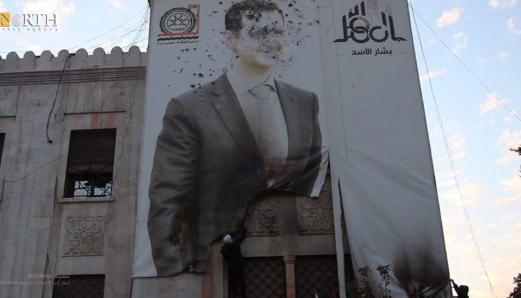 تمزيق صورة لبشار الأسد في حماة - نورث برس