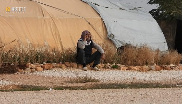 نازح من عفرين يجلس بجانب خيمته في مخيم بريف حلب الشمالي - نورث برس/أرشيفية