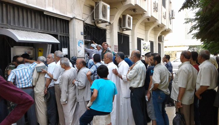 موظفون حكوميون يصطفون في طابور لاستلام رواتبهم/متداول