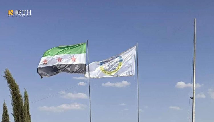 رفع العلم السوري إلى جانب شعار الإدارة الذاتية في معبر سيمالكا - نورث برس