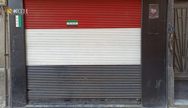 العلم السوري السابق على واجهة محل بدمشق – نورث برس